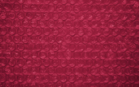 The texture of the packaging air-bubble film colored in the color of the Year 2023 Viva Magenta...