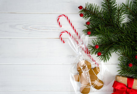 Festive Christmas composition with gingerbread man and fir branches on a white wooden background. Copy space. Top view. Flatlay.の写真素材