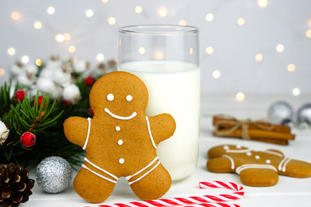 Traditional treat for Santa glass of milk and gingerbread man on the table. Christmas mood....