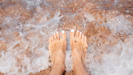 Woman's feet and sea wave. Vacation and travel concept. Close-up.の写真素材