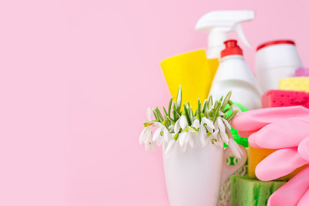 Spring flowers, detergents and cleaners for cleaning the house on a pink background. Spring cleaning. Copy space. Close-up.の写真素材