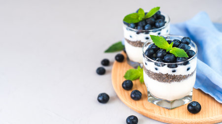 Delicious dessert of blueberries, yogurt and chia seeds for breakfast. Healthy food concept. ?lose-up. Place for text.の写真素材