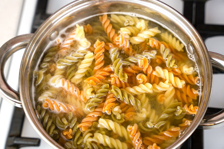 Italian fusilli paste is cooked in a pot on the stove. Top view. Selective focus.の写真素材