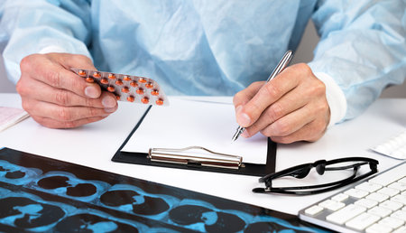 Male doctor writes out a prescription for treating a patient in a hospital. Medicine and healthcare. Close-up.の写真素材