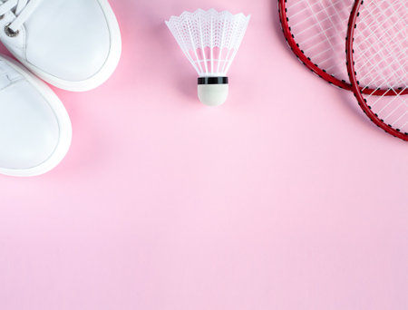 Sport flat lay with white sneakers, shuttlecock and two rackets for playing badminton on a pink background. Concept healthy lifestyle. Top view. Copy space. Banner. Place for text.の写真素材