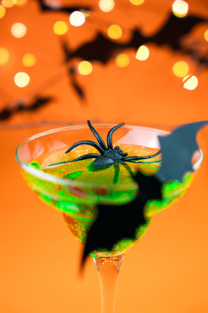 Green cocktail with spiders and a bat. Halloween party. Close-up. Selective focus.の写真素材