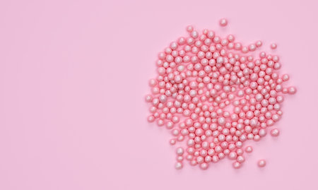 Holidays concept. Decorative small pink balls on a pink background. Top view. Copy space.の写真素材