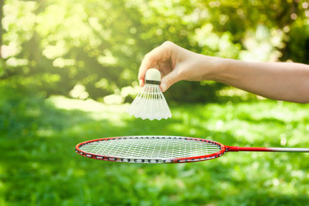 Female hand holds shuttlecock over the racket for playing badminton. Concept healthy lifestyle. Fitness concept. Close-up. copy space.の写真素材