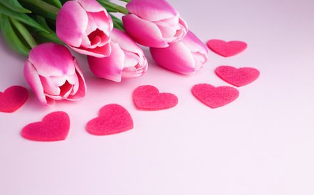 Bouquet pink tulips and red hearts on pink background. Greeting card. Mothers day, March 8, Valentine's Day, Birthday celebration concept. Copy space. Close-up.の写真素材