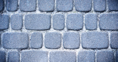 Detailed texture of a stone pedestrian walkway. Top view. Selective focus.
