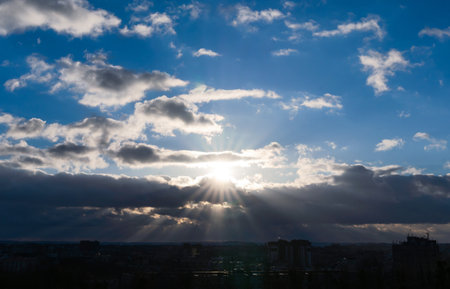 Sun rays break through the clouds. Sunset. Beautiful blue sunset sky with clouds. Natural background. Selective focus.の写真素材