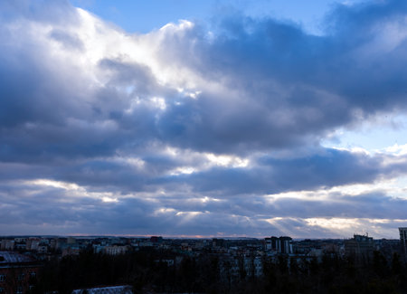 Dramatic blue-gray sky and rays of sun breaking through the clouds. Sunset. Natural background. Selective focus.の写真素材