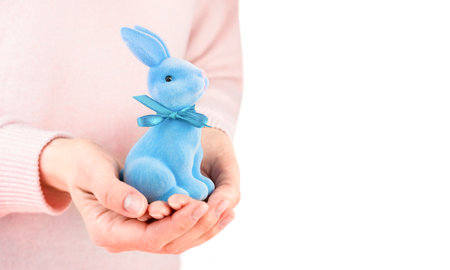 Woman holds decorative Easter Bunny in her hands. Easter decor. Copy space. Selective focus.の写真素材