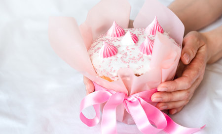 Woman's hands holding Easter cake. Close-up. Copy space. Selective focus.の写真素材