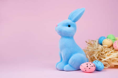 Decorative Easter bunny and Easter eggs on the pink background. Copy space. Selective focus.の写真素材