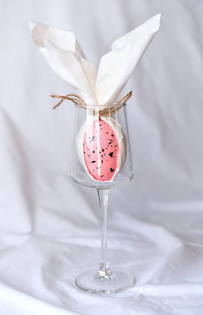 Decorative rabbit made from egg and napkin in wineglass. Creative table setting for Easter. Selective focus.の写真素材