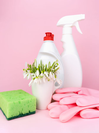 Spring flowers with detergents, kitchen sponge and gloves on a pink background. Close-up. Selective focus.の写真素材