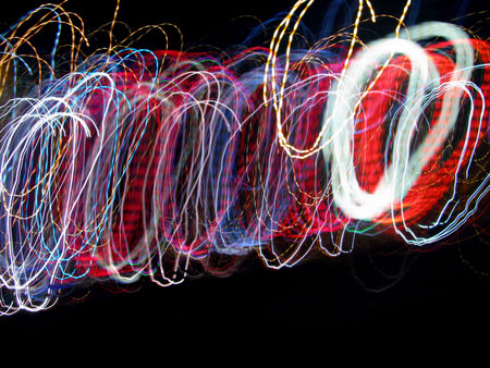 Swirls of Light Abstract Background looks like coils of wire or bracelets on a black background with...