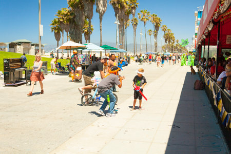 Venice Beach California - July 2012 - A peddler of balloons is gaming with a child in the pedestrian walkway of venice beach los angeles californiaのeditorial素材