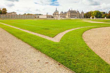 Chantilly September 2012 - In September, the tourists visit the Anglo-Chinese garden in Chantilly Castle to walk  in nature and admire the well kept grass. Panoramic view of the Castle from the garden.のeditorial素材