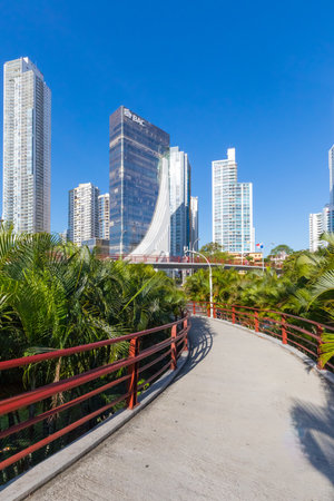 Photo for Panama city Panama January 2019 Pedestrian bridge between the Panama City palms in a sunny day. These pedastrian bridge allows tourist to reach Conta Costera street a green area of the city to walk along the beach. - Royalty Free Image