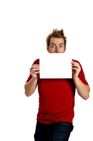 Excited young man in a red shirt and jeans, with wild hair, peering over a blank white sign in front of his chest.の写真素材