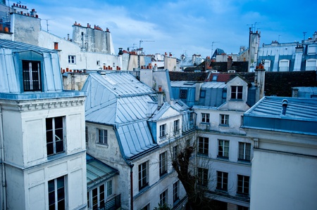 View of a Paris neighborhood skyline, featuring mostly rooftops from the top floor of an apartment building in Paris, France.の写真素材