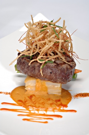 Beautifully plated Grilled Filet Mignon over scalloped potatoes au gratin, topped with deep fried onions. の写真素材