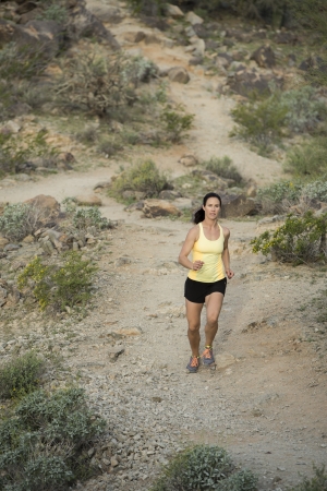 Young woman trail running outdoors at South Mountain Park in Phoenix, Arizona.の写真素材