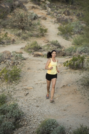 Young woman trail running outdoors at South Mountain Park in Phoenix, Arizona.の写真素材