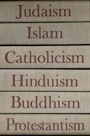 Book spines listing major world religions - Judaism, Islam, Catholicism, Hinduism, Buddhism and Protestantism.の写真素材