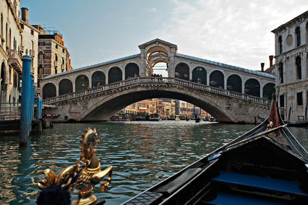 VENICE-APRIL 13: A Gondola on the Grand Canal glides toward the Rialto Bridge in Venice on April 13,2008. Gondola - is one of the symbols of Venice and major mode of touristic transport in Venice, Italy.のeditorial素材