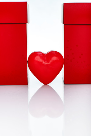 Valentines Day Composition. Two Big Red Gift Boxes And Red Wax Heart On White Reflective Table.の写真素材
