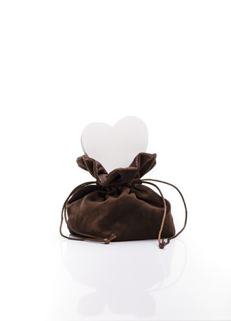 White Wooden Heart In Brown Sack On White Reflective Background. Love Concept.の写真素材