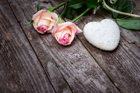 Beautiful Roses And White Heart With Drops Of Rain On Old Wooden Table. Love Concept.の写真素材