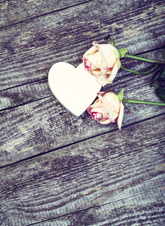 White Wooden Heart And Beautiful Roses On Old Wooden Table. Love Concept.の写真素材