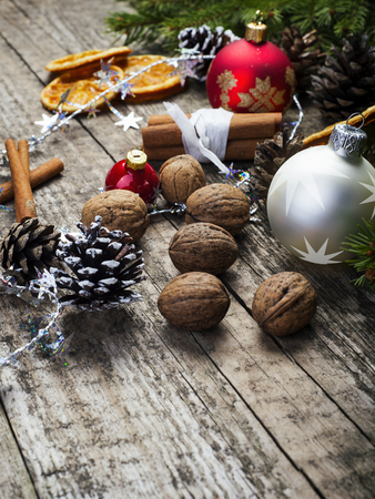 Baubles, Pine Cones, Walnuts, Cinnamon Sticks And Dried Oranges. Christmas Decoration On Old Wooden Board.の写真素材