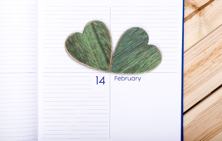 Two Wooden Hearts And Calendar On Wooden Table. February 14. Valentines Day Celebration. Love Conceptの写真素材