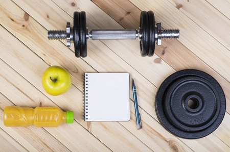 Sport Equipment. Dumbbells, Free Weights, Barbell, Apple, Orange Juice  And Notepad To Workout Plan On Boards. Sport Fitness Backgroundの写真素材