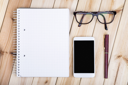 Office Desk With Notepad, Smart Phone, Glasses And Fountain Pen On Wooden Desk.の写真素材