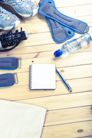 Bottle Of Water And Notepad To Workout Plan On Wooden Table. Sport Fitness Backgroundの写真素材