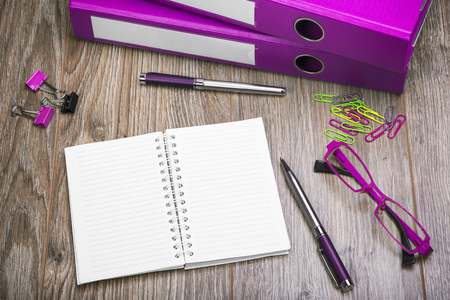 View Of An Office Desk With Ring Binders, Glasses, Notepad And Pen. Workplace With Objects In Color Purple.の写真素材