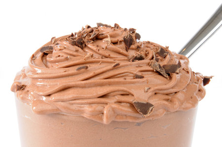 Macro of a glass bowl of chocolate mousse with a white backgroundの写真素材