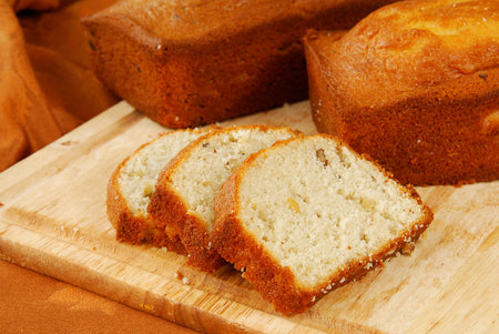 Two loaves of banana nut bread on a cutting board to cool