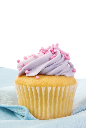 A single cupcake on a blue napkin with frostingの写真素材