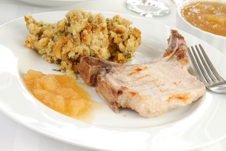 A pork chop with apple sauce and stuffingの写真素材