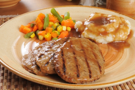 A salisbury steak dinner with vegetablesの写真素材