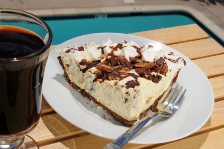A slice of turtle pie with a cup of coffee by the swimming poolの写真素材