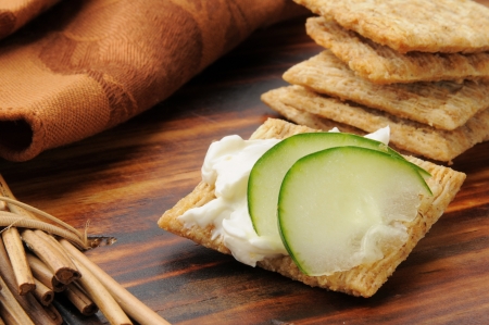 Whole wheat crackers with cream cheese and sliced cucumberの写真素材