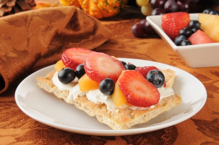 Cream cheese, strawberries, blueberries and cantaloupe on sesame crispbreadの写真素材